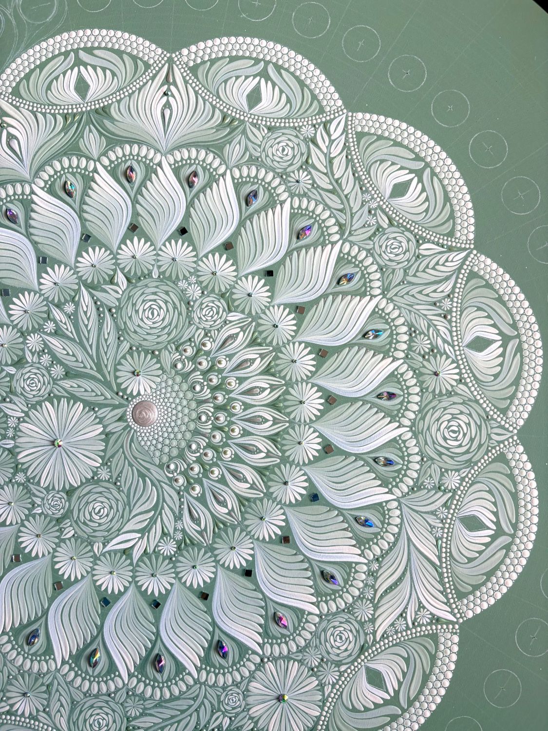 A sage green and white mandala by Lauren, with gems and mirrors