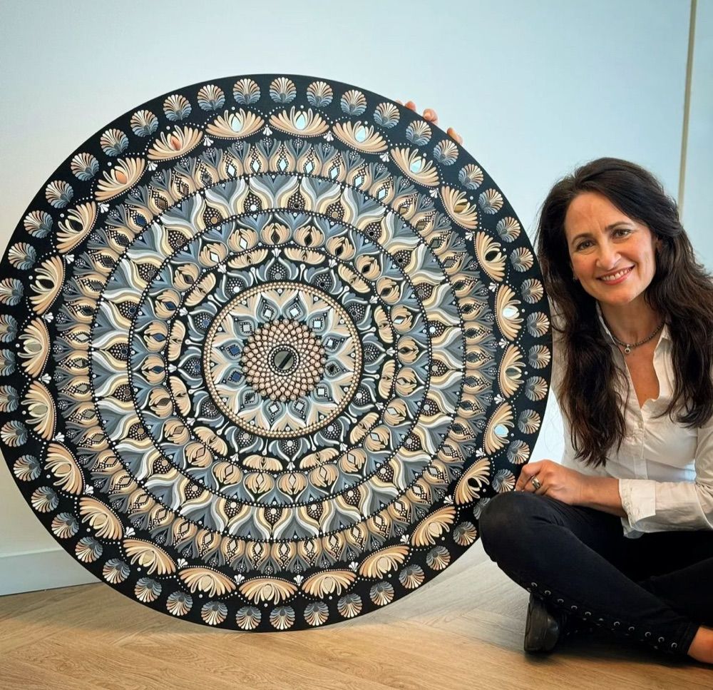 A student showing off their finished mandala piece